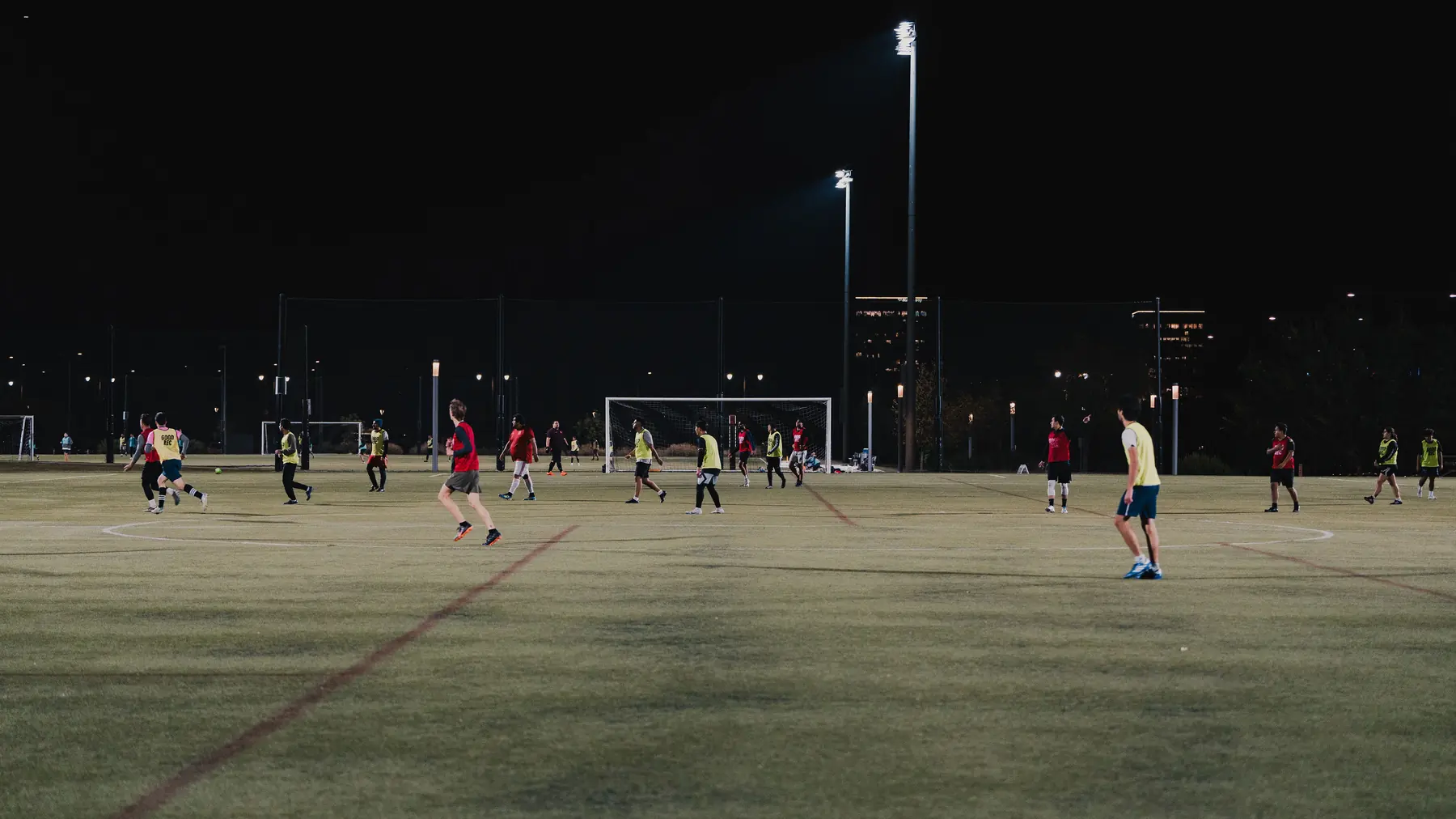An evening game under floodlights on a full-size pitch