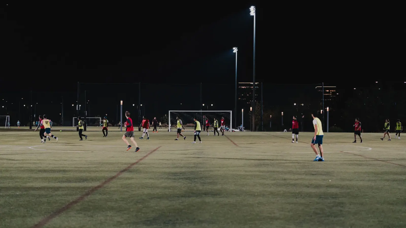 An evening game under floodlights on a full-size pitch